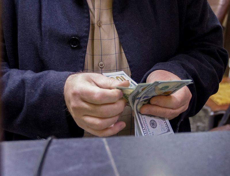 © Reuters. A man counts U.S. dollars at a currency exchange shop in Baghdad, Iraq, January 23, 2023. REUTERS/Ahmed Saad