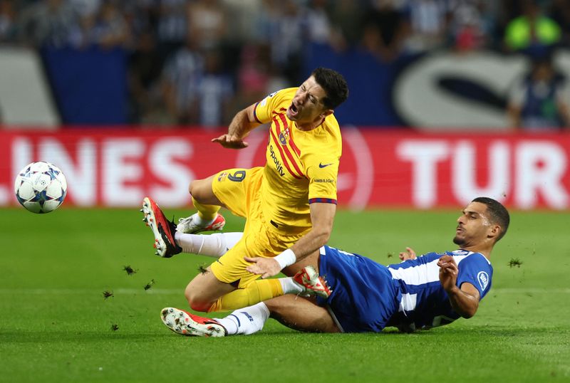 &copy; Reuters. FOTO ARCHIVO: Fútbol - Liga de Campeones - Grupo H - FC Porto vs FC Barcelona - Estadio do Dragao, Porto, Portugal - 4 de octubre de 2023. Robert Lewandowski del FC Barcelona, recibe una falta de David Carmo del FC Porto. REUTERS/Pedro Nunes/File Photo