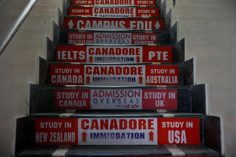 © Reuters. FILE PHOTO: Advertisements of immigration consultants are seen on the stairs at a market in Amritsar, in the northern state of Punjab, India, September 22, 2023. REUTERS/Adnan Abidi/file photo