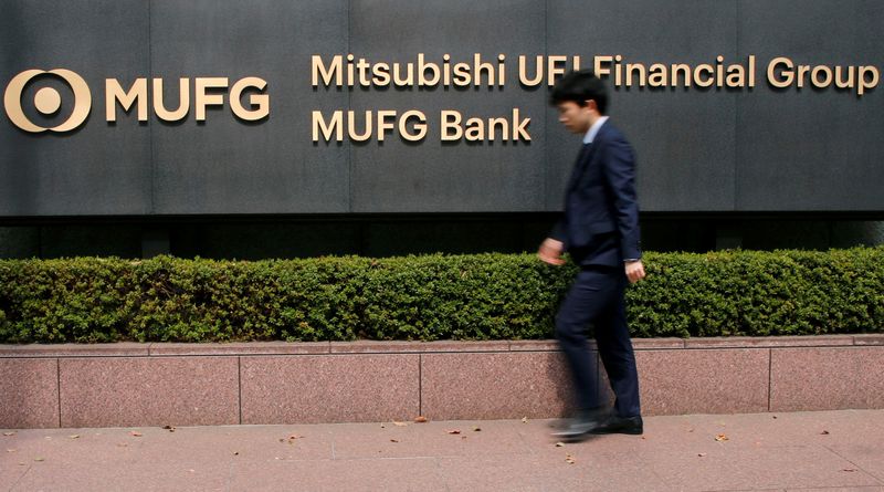 © Reuters. FILE PHOTO: A man walks past a signboard of Mitsubishi UFJ Financial Group and MUFG Bank at its headquarters in Tokyo, Japan April 3, 2018. REUTERS/Toru Hanai/File Photo