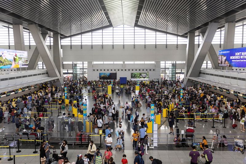 &copy; Reuters. Des passagers font la queue pour s'enregistrer à l'aéroport international Ninoy-Aquino, aux Philippines /Photo prise le 2 janvier 2023/REUTERS/Eloisa Lopez 