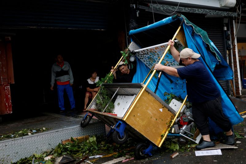 &copy; Reuters. عمال يرفعون عربة طعام عقب إعصار كوينو بتايوان يوم الخميس. تصوير: كارلوس جارسيا رولينز - رويترز.

