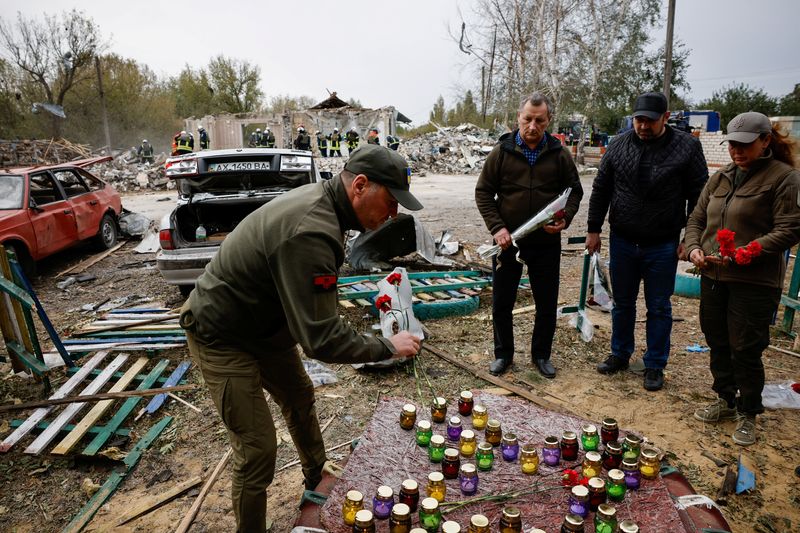 &copy; Reuters. أشخاص يضعون الزهور تكريما للضحايا في موقع ضربة عسكرية روسية في قرية هوروزا بمنطقة خاركيف في أوكرانيا يوم الجمعة. تصوير: توماس بيتر - رويترز.
