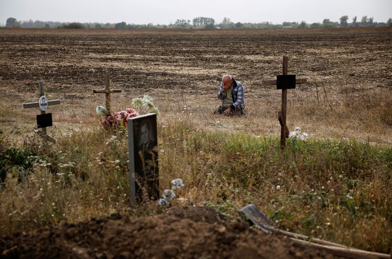 &copy; Reuters. Valeriy Kozyr, de 61 anos, chora ao lado de sepulturas depois de perder sua filha e outros parentes em um ataque militar russo no vilarejo de Hroza, na Ucrânia
06/10/2023 REUTERS/Thomas Peter