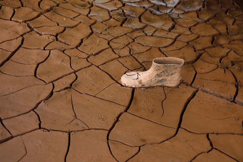 © Reuters. FILE PHOTO: A plastic boot is pictured on dry cracked mud at a house affected by the floods due to the rains brought by Hurricanes Eta and Iota, in Villanueva, Honduras December 6, 2020. Picture taken December 6, 2020. REUTERS/Jose Cabezas