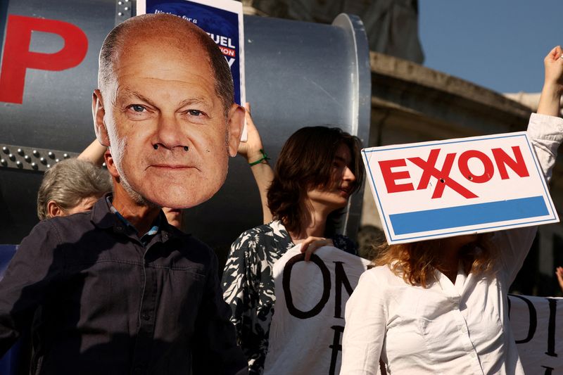 © Reuters. FILE PHOTO: Environmental activists wear masks depicting German Chancellor Olaf Scholz and an Exxon logo during a climate strike action to call on leaders to end fossil finance and make polluters pay at the Place de la Republique, on the sidelines of the New Global Financial Pact Summit, in Paris, France, June 23, 2023. REUTERS/Stephanie Lecocq/File Photo