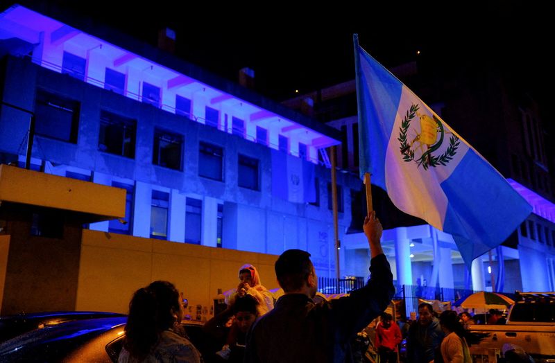 &copy; Reuters. FILE PHOTO: A demonstrator holds up a Guatemalan national flag during a blockade of the Public Ministry building to demand the resignation of powerful senior prosecutors accused of working to undermine President-elect Bernardo Arevalo's ability to take of