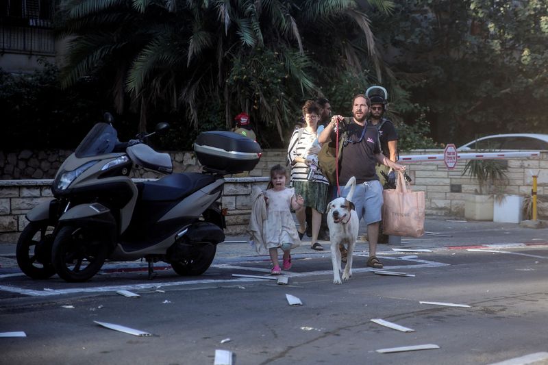 &copy; Reuters. إسرائيليون في أحد شوارع تل أبيب خلال إطلاق صواريخ من غزة يوم السبت. تصوير: إيتاي رون - رويترز