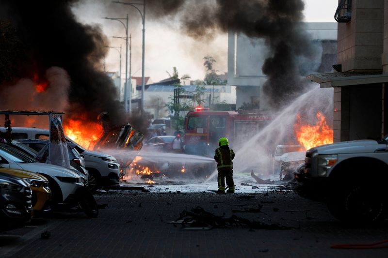 &copy; Reuters. رجل إطفاء يعمل على إخماد نيران في مدينة عسقلان بعد إطلاق صواريخ من قطاع غزة على إسرائيل يوم السبت. تصوير: عامير كوهين - رويترز.