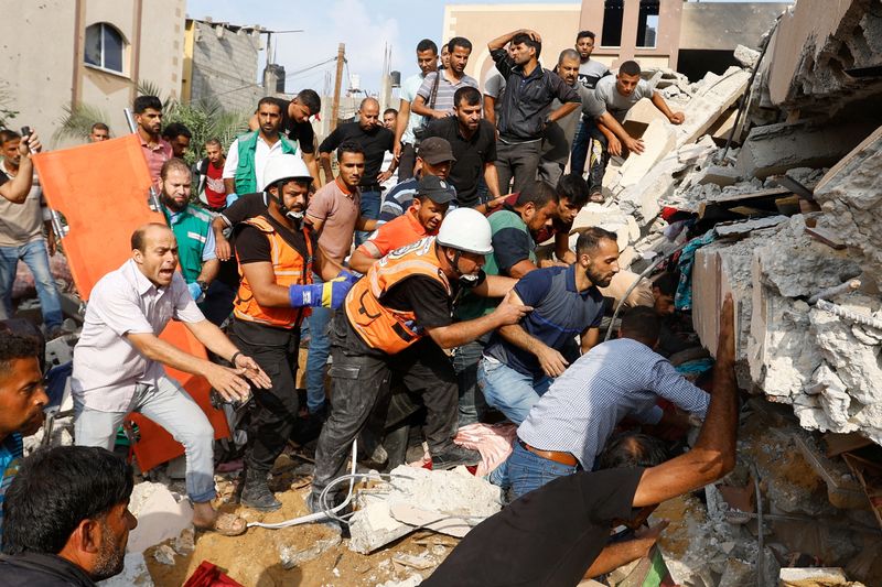 &copy; Reuters. فلسطينيون يبحثون تحت ركام منزل تعرض لقصف إسرائيلي عن مصابين في مدينة خان يونس جنوب قطاع غزة يوم الأحد. تصوير: إبراهيم أبو مصطفى - رويترز.