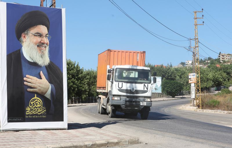 &copy; Reuters. عربة تابعة للأمم المتحدة تسير بالقرب من صورة لزعيم حزب الله السيد حسن نصر الله في قرية بالقرب من الحدود اللبنانية الإسرائيلية جنوب لبنان يو