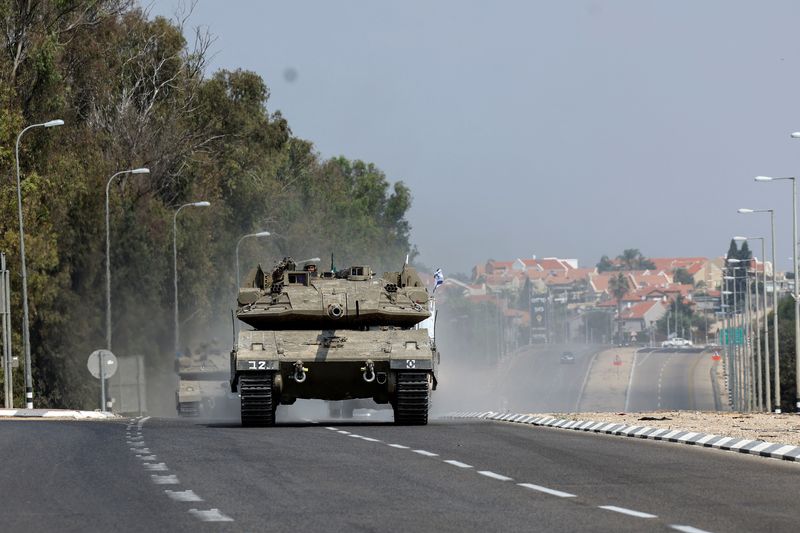 &copy; Reuters. دبابات إسرائيلية تسير في طريق عقب تسلل جماعي لمسلحين من حماس في قطاع غزة بالقرب من سديروت في جنوب إسرائيل يوم الأحد. تصوير: رونين زفولون - روي