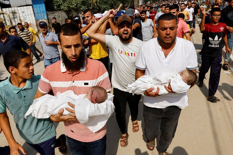 &copy; Reuters. Palestinos carregam corpos de bebês gêmeos mortos em ataques de Israel junto com suas três irmãs e sua mãe, segundo relatos de autoridades de saúde em Gaza.
REUTERS/Ibraheem Abu Mustafa