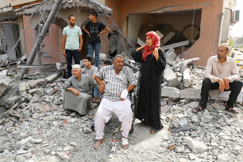 &copy; Reuters. فلسطينيون يشاهدون فريق الدفاع المدني أثناء بحثهم عن الضحايا المحاصرين تحت الأنقاض في خان يونس بجنوب قطاع غزة يوم الأحد. تصوير: إبراهيم أبو م
