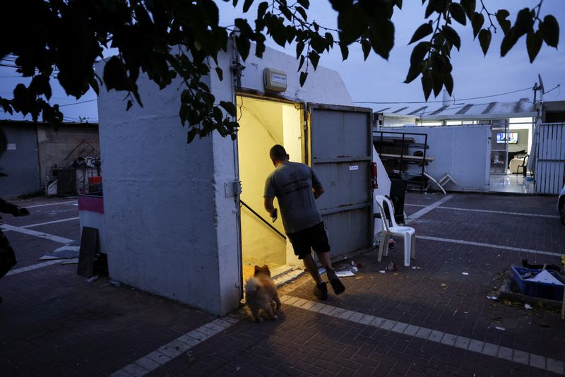 &copy; Reuters. A man and a dog run to a bomb shelter as rockets from Gaza are launched towards Israel in Ashkelon, southern Israel October 8, 2023. REUTERS/Ronen Zvulun