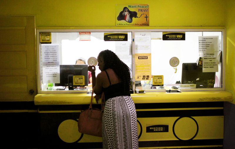 &copy; Reuters. FILE PHOTO: A woman uses a money wire service at a supermarket in Belize City, Belize June 22, 2016. To match special report USA-BANKING/CARIBBEAN. REUTERS/Jose Cabezas/File Photo