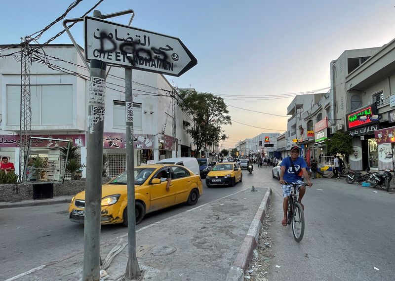 &copy; Reuters. A man rides a bicycle past a sign directing to Ettadamen district, in Tunis, Tunisia June 24, 2022. Picture taken June 24, 2022. REUTERS/Jihed Abidellaoui