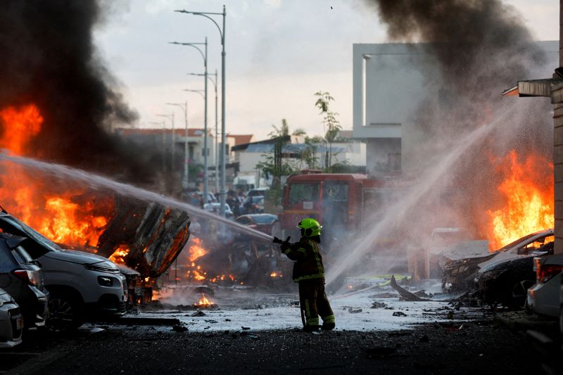 &copy; Reuters. أحد أفراد الطوارئ يعمل على إطفاء الحريق بعد إطلاق الصواريخ من قطاع غزة في مدينة عسقلان بإسرائيل بتاريه السابع من أكتوبر تشرين الأول 2023. تصوي