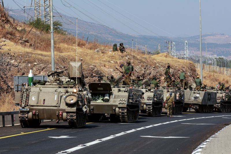 &copy; Reuters. قافلة من حاملات الجند المدرعة تسير في طريق بالقرب من الحدود الإسرائيلية مع لبنان يوم الاثنين. تصوير: عمار عوض - رويترز.