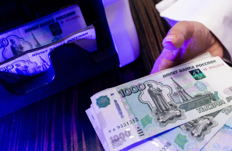 © Reuters. An employee holds Russian 1000-rouble banknotes next to a currency counting machine in a bank office in Moscow, Russia, in this illustration picture taken October 9, 2023. REUTERS/Maxim Shemetov/Illustration