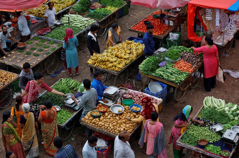 &copy; Reuters. FILE PHOTO: Customers buy fruits and vegetables at an open air evening market in Ahmedabad, India, August 21, 2023. REUTERS/Amit Dave/File photo