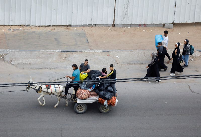 &copy; Reuters. FILE PHOTO: Palestinians fleeing their homes amid Israeli strikes, ride a donkey cart carrying their belongings, in Gaza City October 10, 2023. REUTERS/Saleh Salem/File Photo