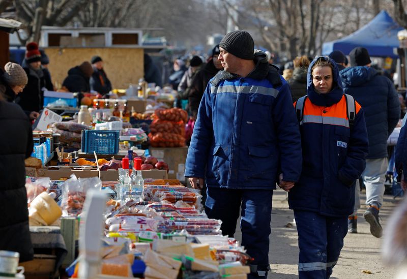 &copy; Reuters. FILE PHOTO: People shop at a local market in the course of Russia-Ukraine conflict in Mariupol, Russian-controlled Ukraine, February 11, 2023. REUTERS/Alexander Ermochenko/File photo