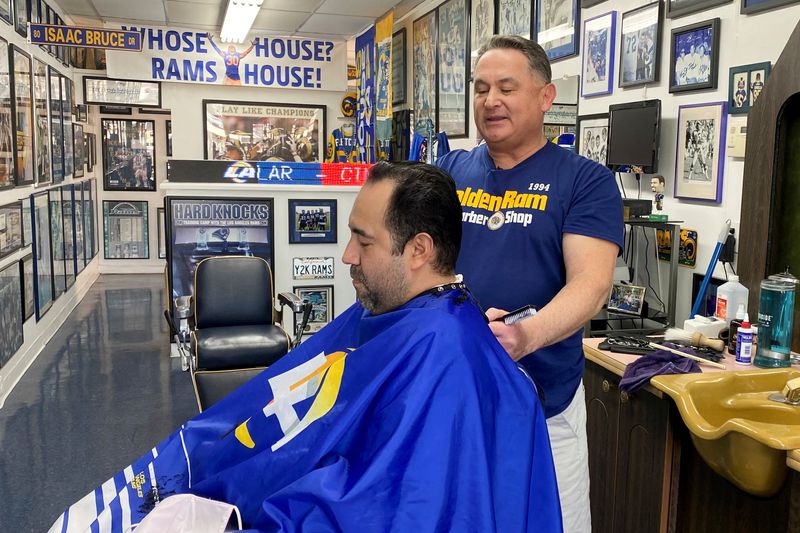 &copy; Reuters. FILE PHOTO: Barber Sal Martinez cuts 42-year-old customer Tom Torres?s hair at his Los Angeles Rams themed barber shop, ahead of the Super Bowl in Westminster, California, U.S., February 9, 2022. REUTERS/Norma Galeana/File Photo