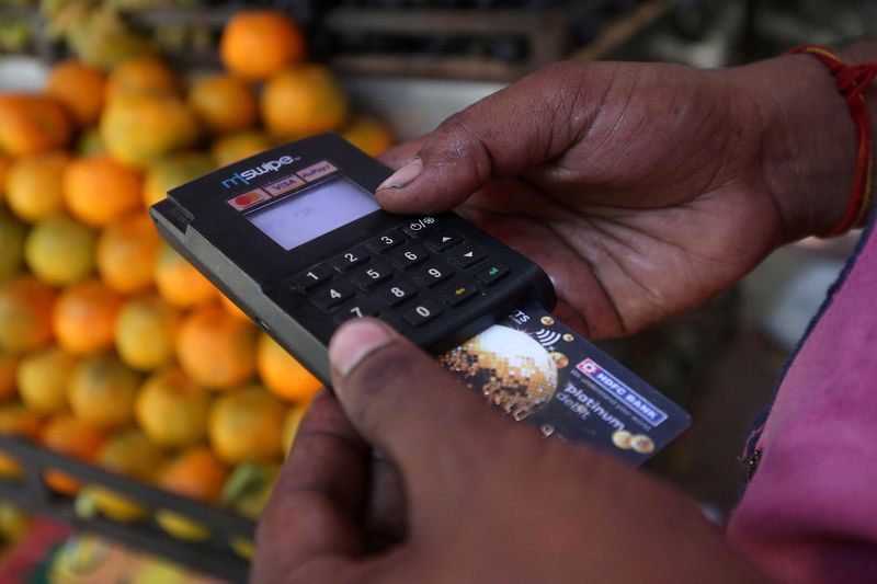 &copy; Reuters. FILE PHOTO: FILE PHOTO: A fruit seller swipes a customer's debit card at a roadside market in Mumbai, India, April 2, 2019. REUTERS/Francis Mascarenhas/File Photo