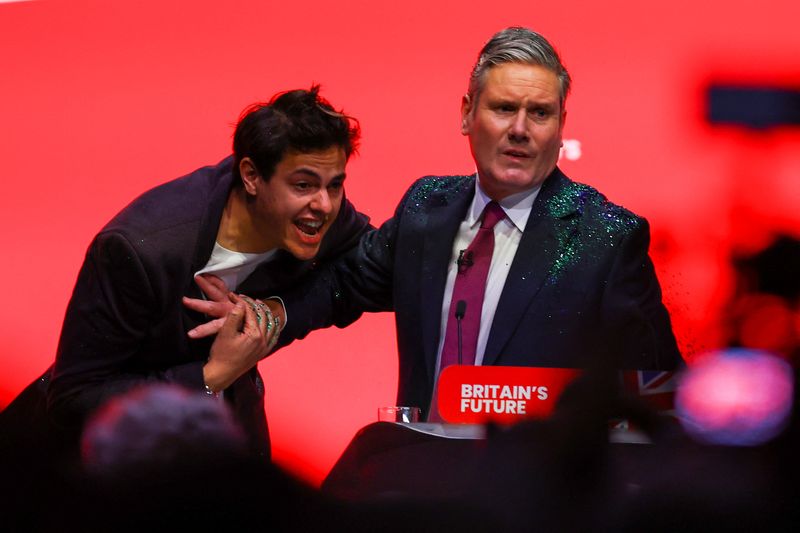 © Reuters. Britain’s Labour Party Leader Keir Starmer pushes a protester who threw glitter on him, at Britain's Labour Party annual conference in Liverpool, Britain, October 10, 2023. REUTERS/Molly Darlington