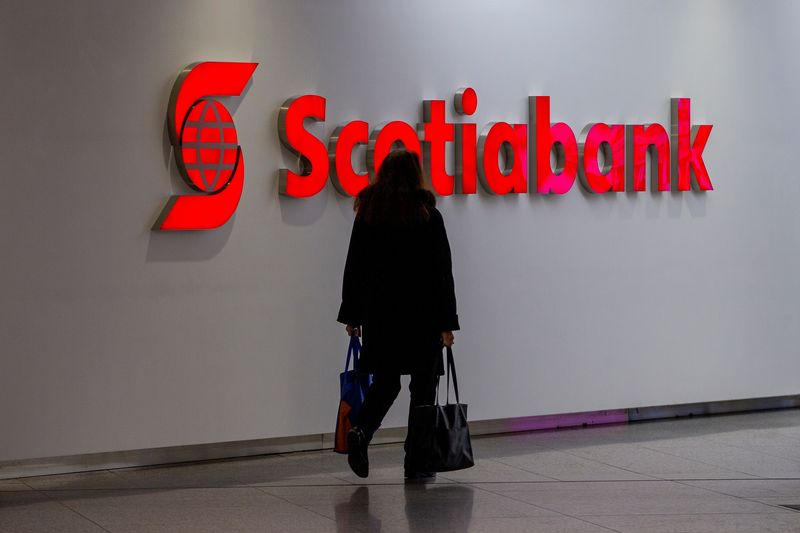 © Reuters. FILE PHOTO: A person walks infant of a sign for The Bank of Nova Scotia, operating as Scotiabank, in Toronto, Ontario, Canada December 13, 2021.  REUTERS/Carlos Osorio