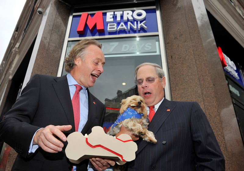 © Reuters. FILE PHOTO: Chairman Anthony Thomson (L) and Vice Chairman Vernon Hill pose with a dog outside the first branch of Metro Bank in Holborn in central London July 29, 2010. REUTERS/Toby Melville/File Photo