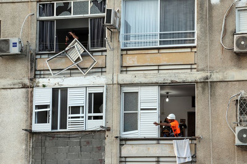 &copy; Reuters. An Israeli emergency responder gestures from the window of a damaged building after a rocket, launched from the Gaza Strip into Israel landed in Ashkelon, southern Israel, October 10, 2023. REUTERS/Ronen Zvulun