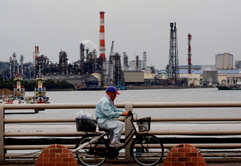 &copy; Reuters. A man cycles past chimneys of facotries at the Keihin Industrial Zone in Kawasaki, Japan September 12, 2018. REUTERS/Kim Kyung-Hoon/ File Photo