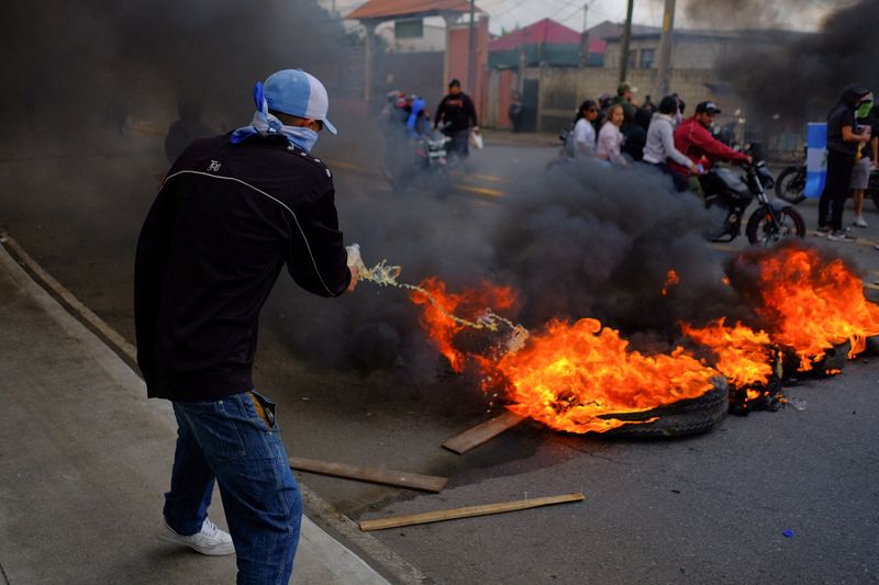 © Reuters. A man pours a liquid on a burning barricade, as part of a national strike to demand the resignation of authorities from the attorney general's office, in Guatemala City, Guatemala October 10, 2023. REUTERS/Josue Decavele