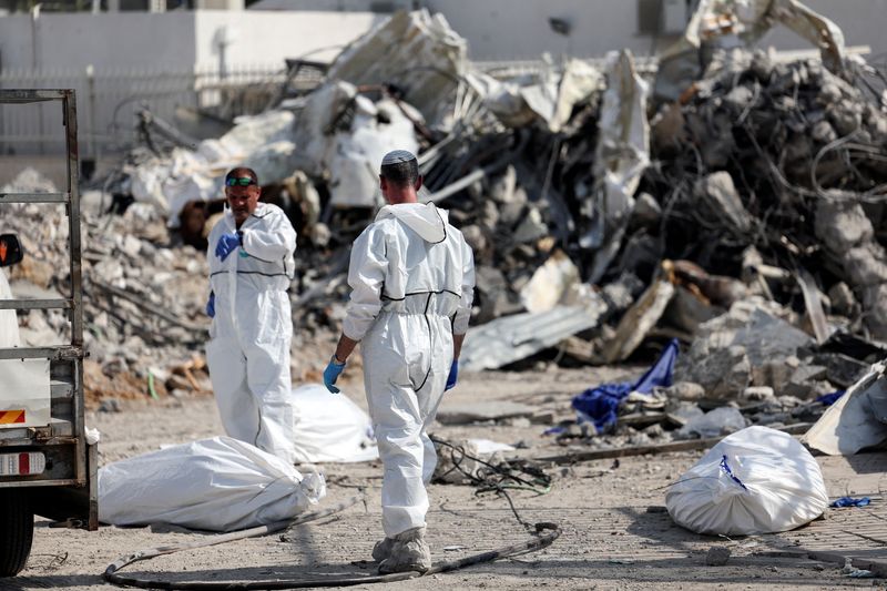 &copy; Reuters. عمال إغاثة ينتشلون جثث لقتلى في سديروت يوم الأربعاء. رويترز