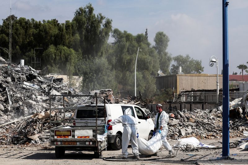 &copy; Reuters. رجال إغاثة في سديروت ينتشلون الجثث من بين الحطام يوم الأربعاء. رويترز
