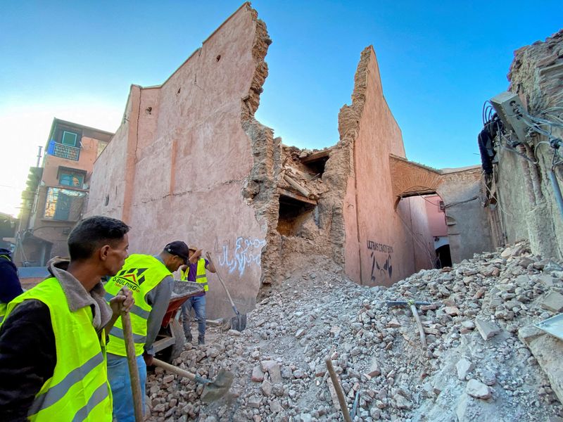 &copy; Reuters. FILE PHOTO: People work next to damage in the city of Marrakech, following a powerful earthquake in Morocco, September 9, 2023. REUTERS/Abdelhak Balhaki/File Photo