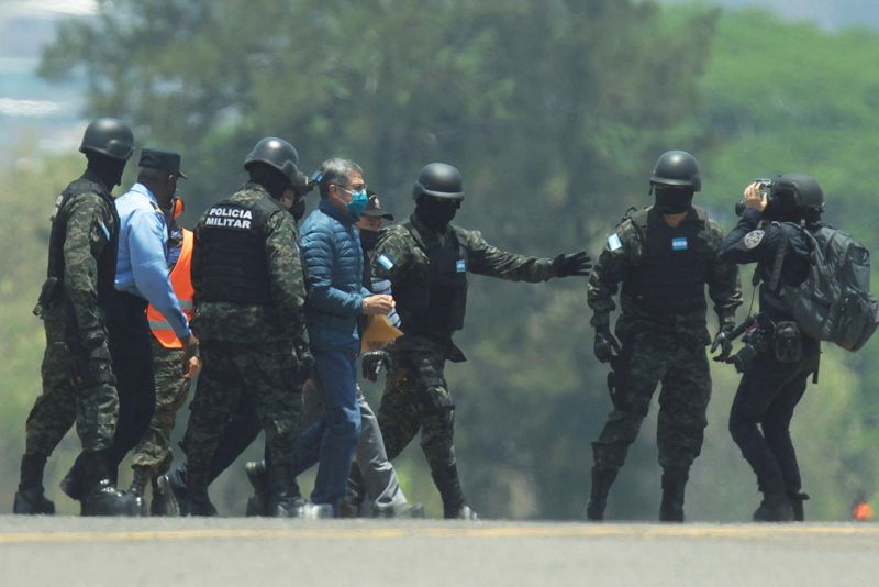 &copy; Reuters. FILE PHOTO: Honduras former President Juan Orlando Hernandez is escorted by members of the National Police and the Military Police after arriving to the Hernan Acosta Mejia Air Force Base for his extradition to the United States, to face a trial on drug t
