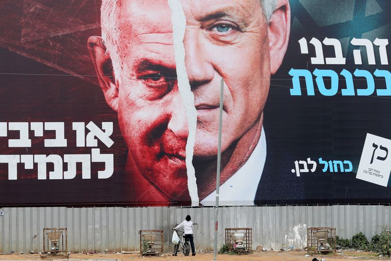 &copy; Reuters. Une affiche électorale montrant Benjamin Netanyahu (à droite) et Benny Gantz (à gauche). /Photo prise le 22 mars 2021/REUTERS/Ammar Awad
