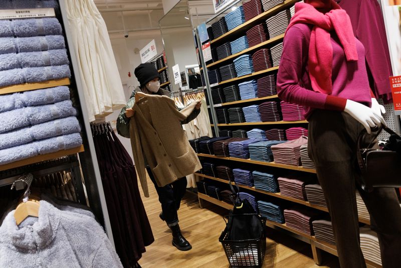 &copy; Reuters. FOTO DE ARCHIVO. Un cliente mira una chaqueta de punto en una tienda del minorista de moda rápida Uniqlo en el distrito comercial de Sanlitun en Pekín, China. 6 de noviembre de 2021. REUTERS/Thomas Peter