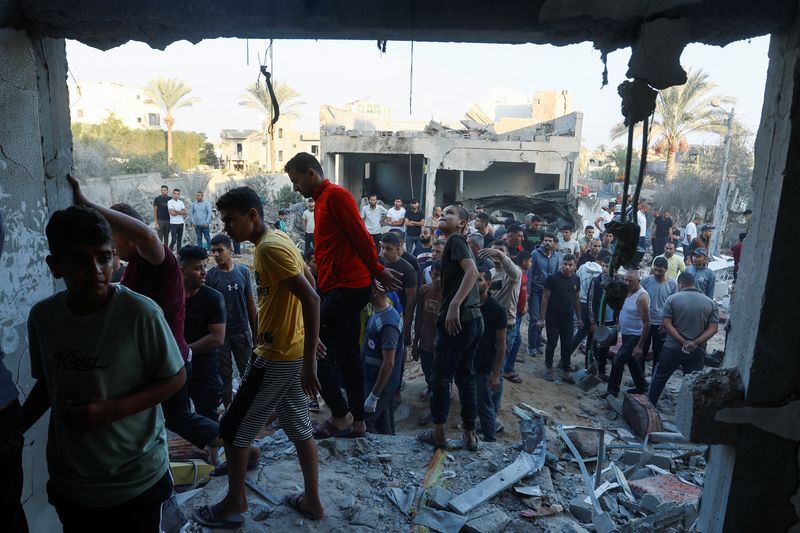 © Reuters. فلسطينيون يتفقدون الدمار الذي لحق بمنزل جراء قصف إسرائيلي على مدينة خان يونس جنوبي قطاع غزة يوم الخميس. تصوير: إبراهيم أبو مصطفى - رويترز.