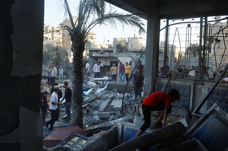 &copy; Reuters. Um palestino caminha pelos destroços de uma casa destruída em ataques israelenses no meio do conflito com Israel em Khan Younis, no sul da Faixa de Gaza, em 12 de outubro de 2023. REUTERS/Ibraheem Abu Mustafa.