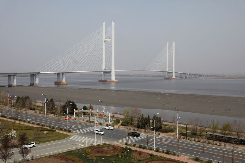 © Reuters. Cars travel past the New Yalu River Bridge designed to connect China's Dandong New Zone and North Korea's Sinuiju, in Dandong, Liaoning province, China April 20, 2021. Picture taken April 20, 2021.  REUTERS/Tingshu Wang