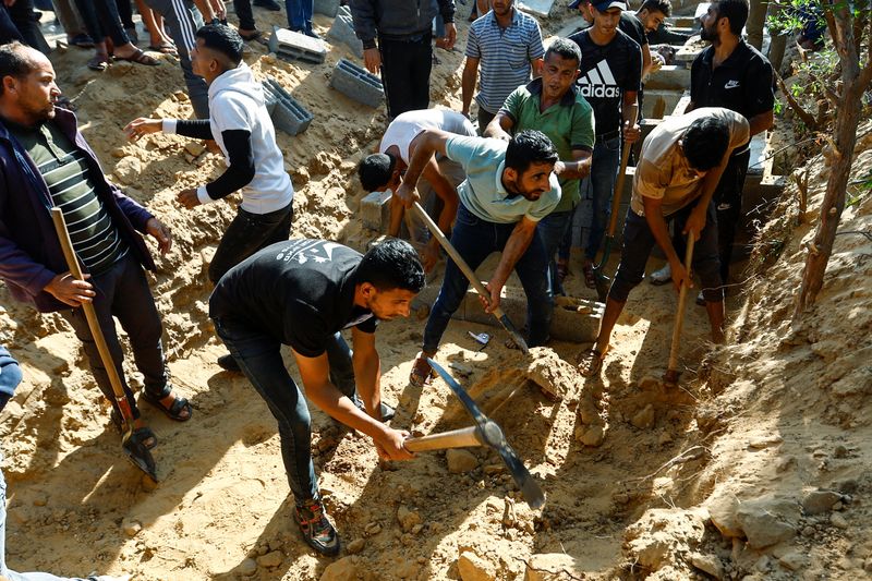 &copy; Reuters. أشخاص يحفرون قبور لدفن جثامين من عائلة سمور الفلسطينية التي قتلت في غارات إسرائيلية في خان يونس بجنوب قطاع غزة يوم الخميس. تصوير: إبراهيم أب