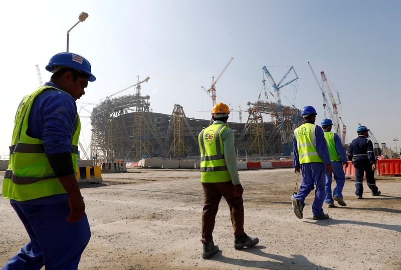 &copy; Reuters. FILE PHOTO: Workers walk towards the construction site of the Lusail stadium which will be build for the upcoming 2022 Fifa soccer World Cup during a stadium tour in Doha, Qatar, December 20, 2019.  REUTERS/Kai Pfaffenbach/File Photo