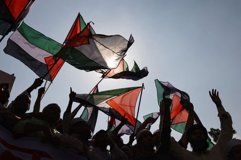 © Reuters. نشطاء مسلمون في بنجلادش يلوحون بالأعلام الفلسطينية خلال احتجاج على الإجراءات الإسرائيلية ضد الفلسطينيين عقب صلاة الجمعة في دكا يوم الجمعة. تصوير: محمد بونير حسين - رويترز.