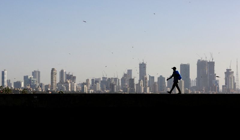 &copy; Reuters. FILE PHOTO: A man walks along a wall overlooking the central Mumbai's financial district skyline, India, March 9, 2017. REUTERS/Danish Siddiqui/File Photo