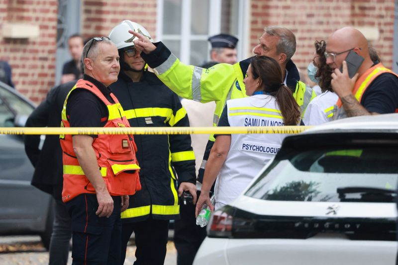 © Reuters. عمال الإنقاذ الفرنسيون في موقع جريمة قتل مدرس وإصابة عدة أشخاص في هجوم بسكين في مدرسة بمدينة أراس بشمال فرنسا يوم الجمعة. تصوير: باسكال روسينول-رويترز.