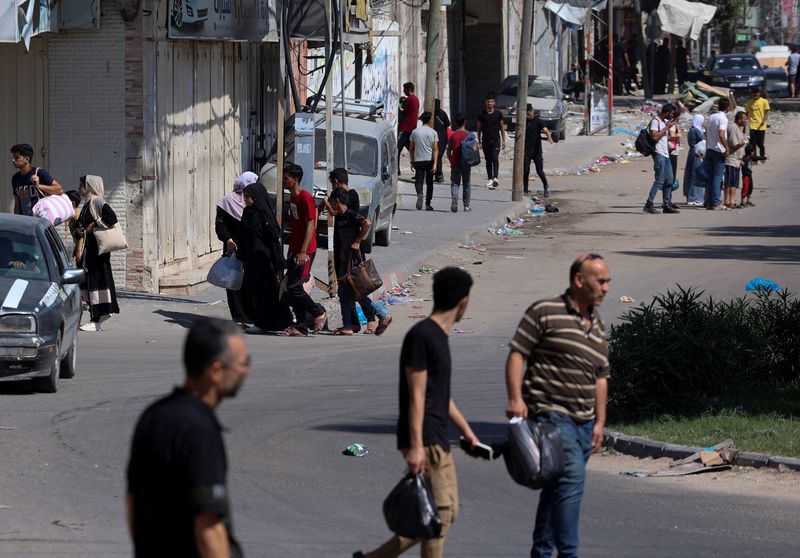 © Reuters. فلسطينيون يفرون من منازلهم متجهين نحو  جنوب قطاع غزة بعد دعوة إسرائيل لأكثر من مليون مدني في شمال غزة للتحرك جنوبا في غضون 24 ساعة في مدينة غزة يوم الجمعة. تصوير: أحمد زقوت - رويترز.